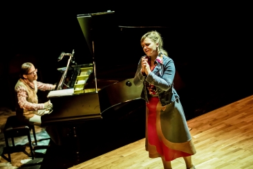 Sophie de Palma stoi na środku sceny, obok przy fortepianie  siedzi Manny Weinstock 